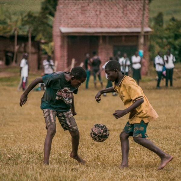 Deux garçons jouant au football sur un terrain